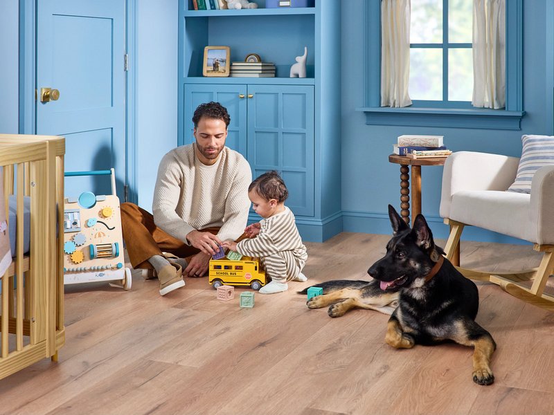 Father, child and dog playing on floor